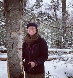 lior smiles in snowy woods next to a tree